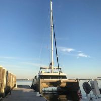 A sailboat docked at a marina on a clear day.