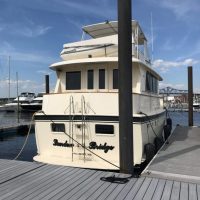 A white yacht named "Silver Lady" docked at a marina on a sunny day.