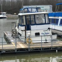 A white and blue boat named Bay Runner docked at a marina.