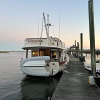 A boat docked at a pier during sunset.